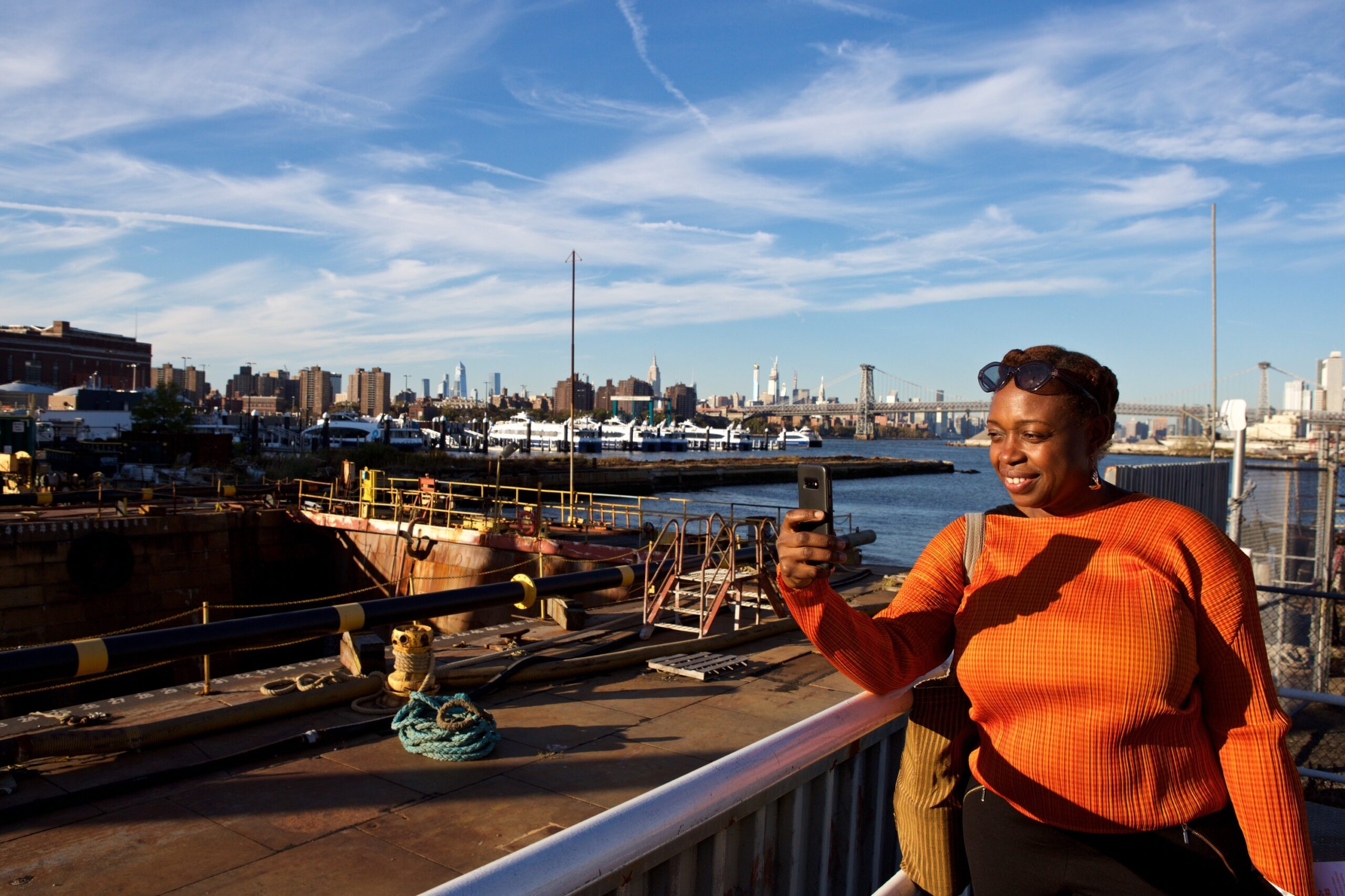 Visitor during OHNY Wknd 2019 taking a photo with historic Dry Dock No. 1 against the Manhattan skyline